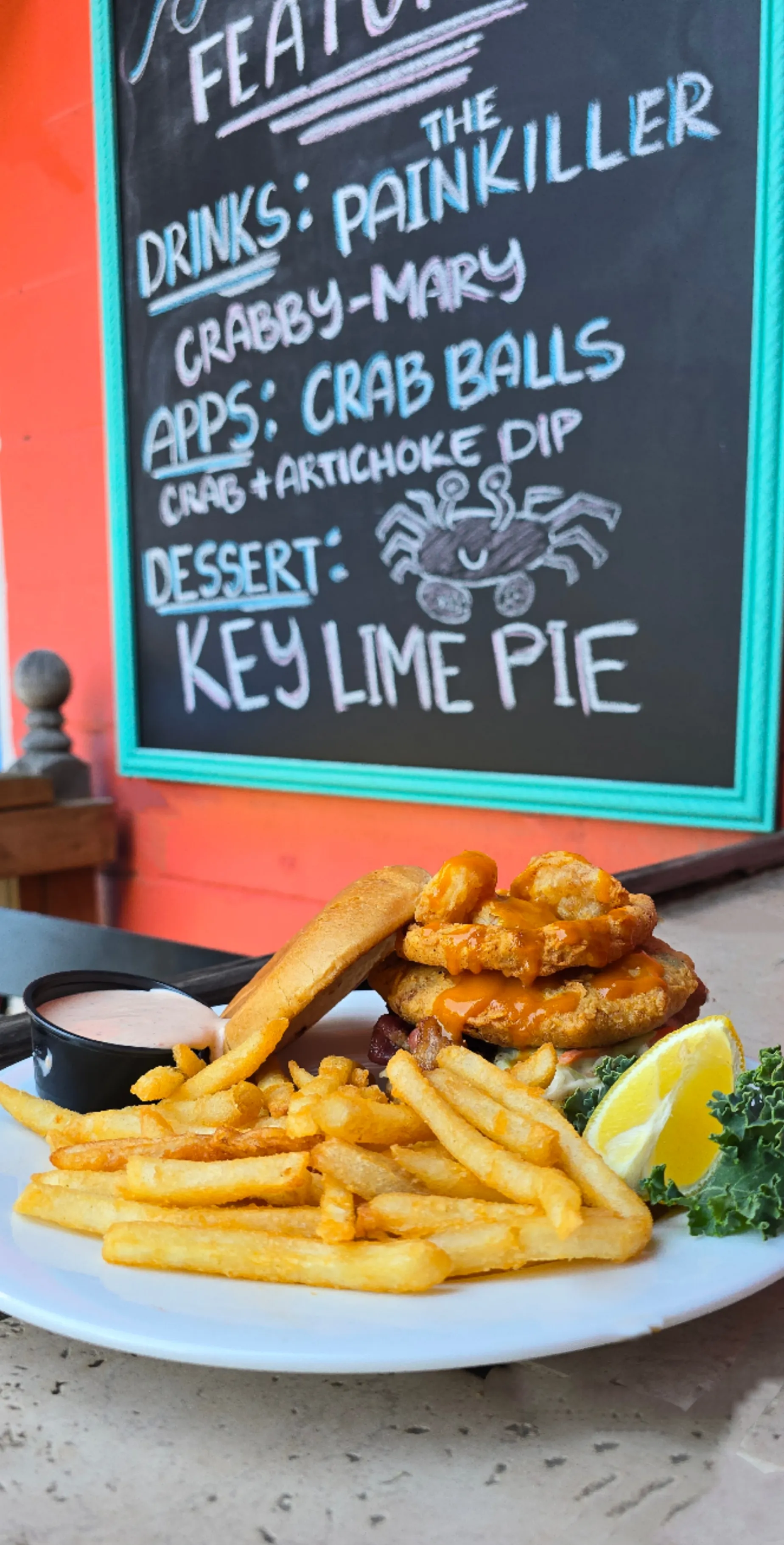 The “Double D” BBQ Shrimp & Crab Sandwich — BBQ deviled crab and fried creek shrimp topped with scallions, bacon, fried onion strings, and coleslaw, served with golden fries.