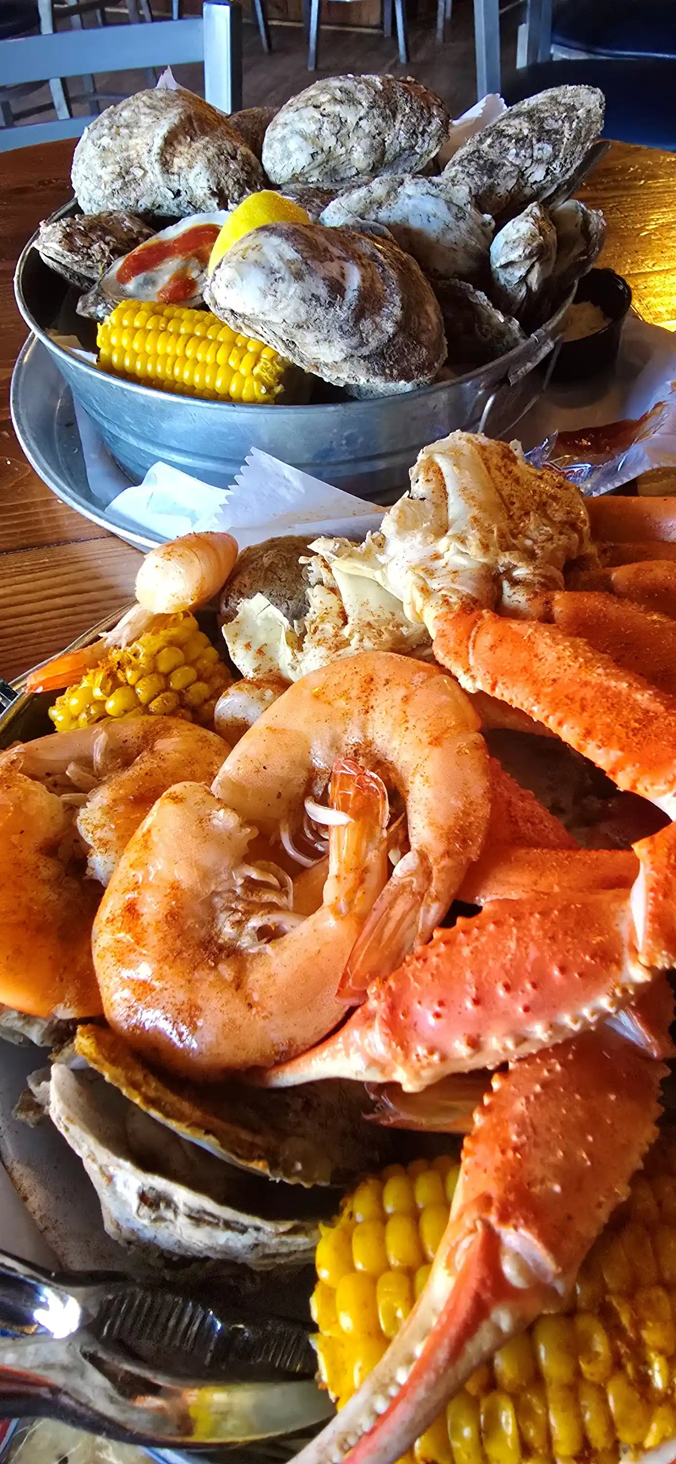 The Charleston Steamed Seafood Bucket — steamed snow crab clusters, large shrimp, and steamed oysters served with corn on the cob, a true taste of the coast.