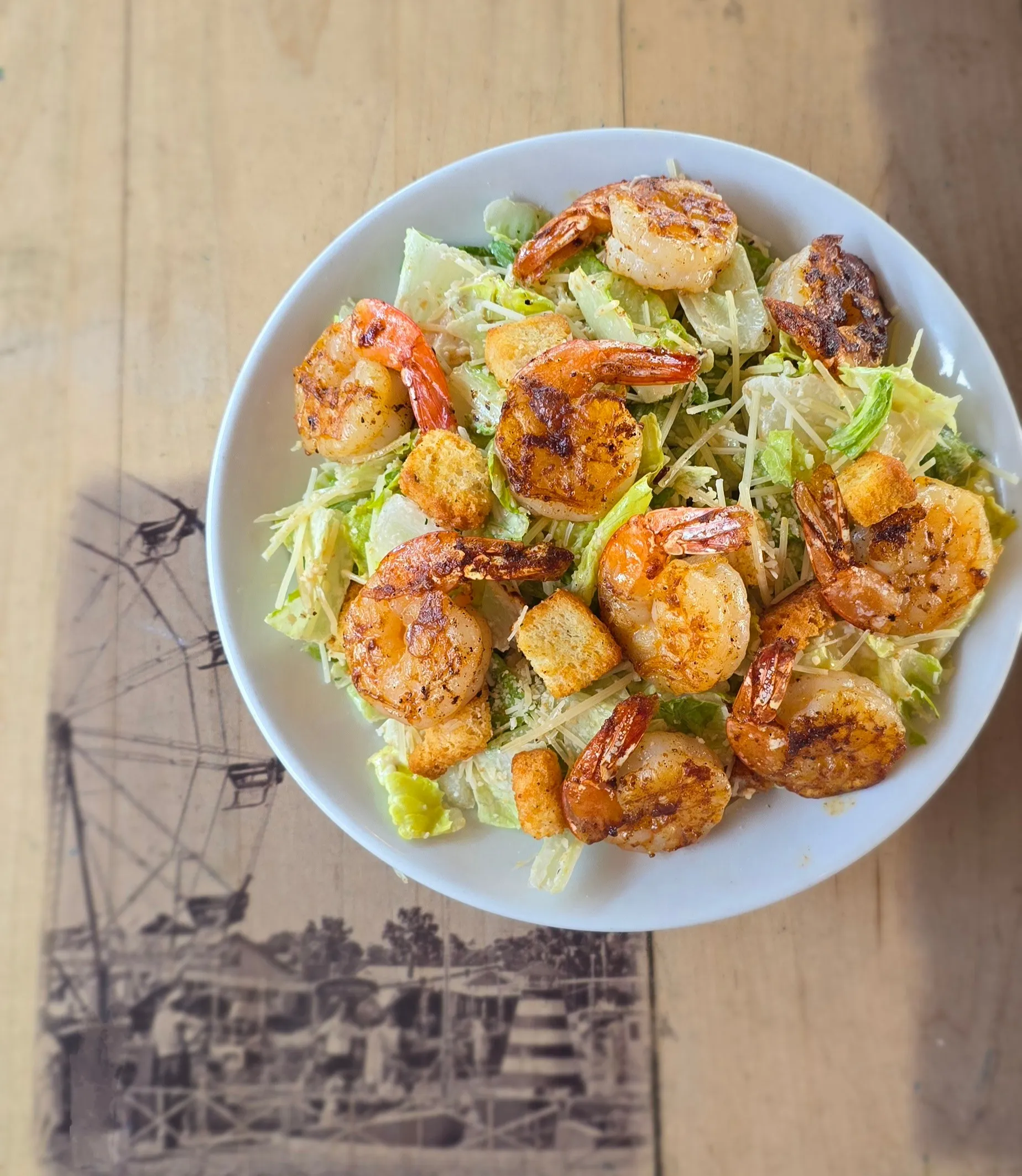 Crisp romaine Caesar salad topped with seared shrimp, shaved parmesan, and golden croutons.