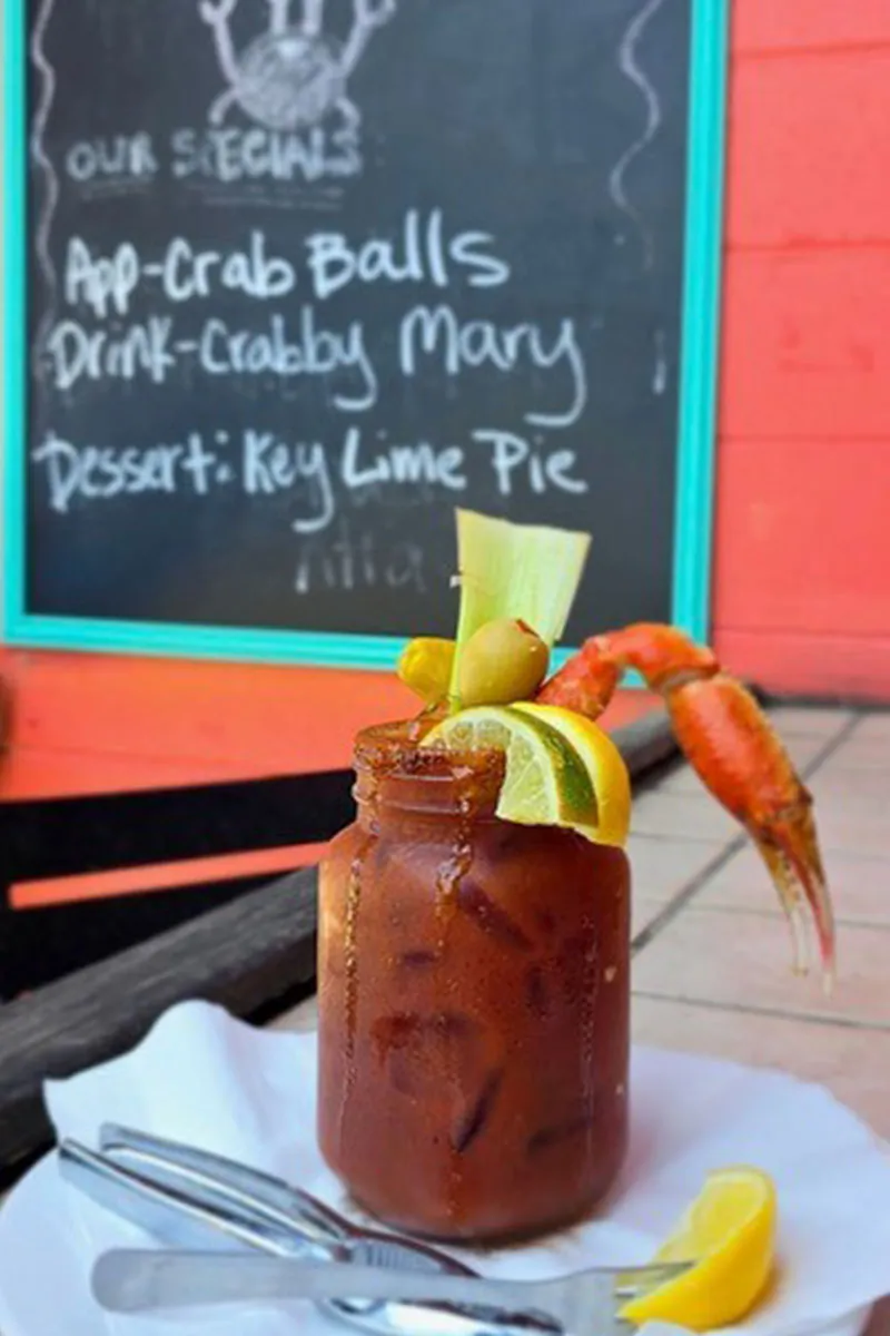 Signature Bloody Mary with jumbo crab claw garnish at The Crab Shacks — classic Charleston SC seafood bar drink