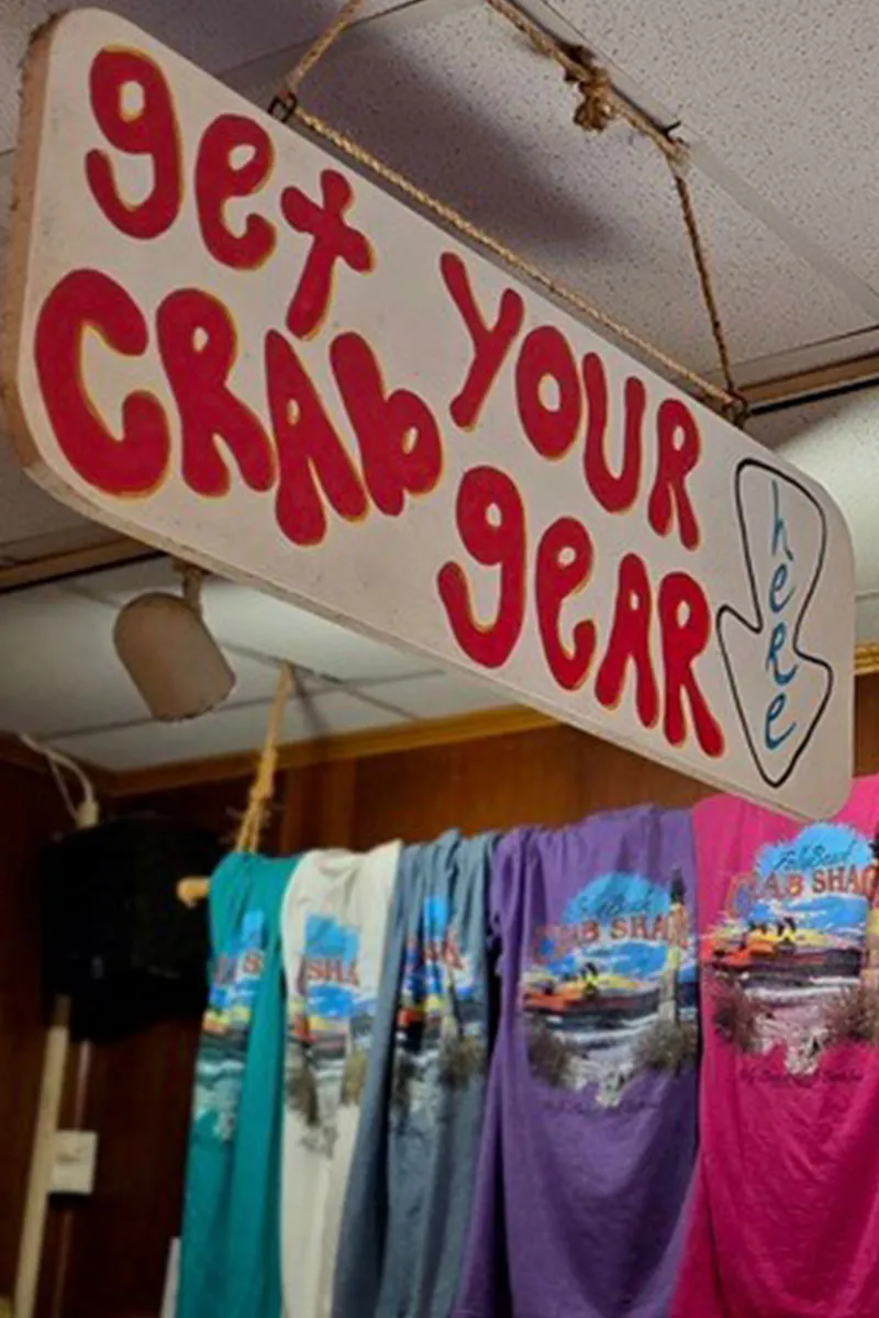 The Crab Shacks branded merchandise for sale — souvenir T-shirts, hats, and coastal seafood restaurant gear in Charleston SC