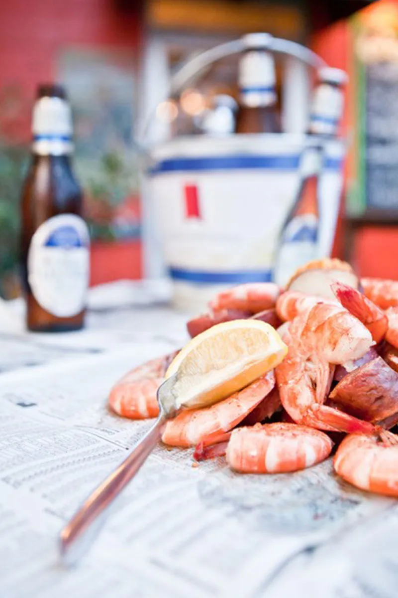 Bucket of fresh steamed shrimp and cold drinks at The Crab Shacks Folly Beach — classic Lowcountry seafood just a few blocks from the beach